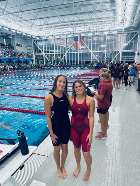 Two women standing next to each other in a swimming poolDescription automatically generated